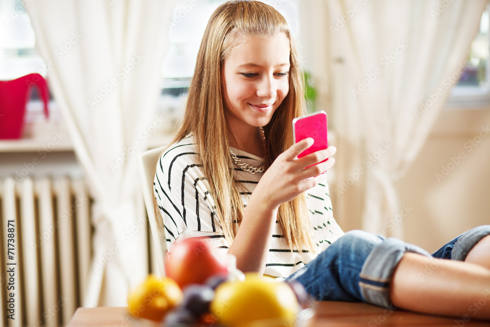 Teenage girl texting message, on mobile phone, at home Teenage girl texting message, on mobile phone, at home
