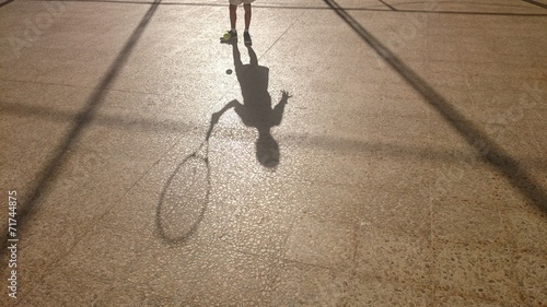 Sombra de niño con raqueta y pelota photo