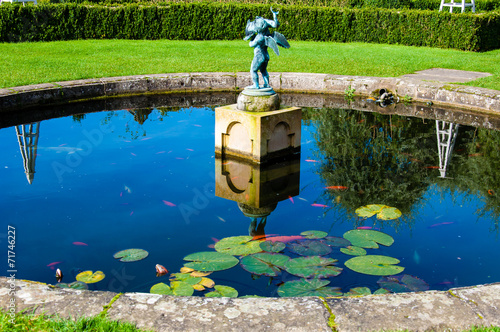 English Landscape garden in Summertime with fishpond and statue photo