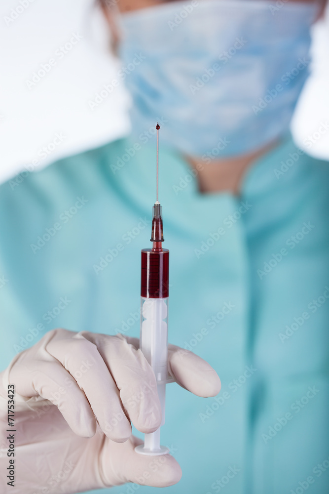 Doctor holding syringe with a blood Doctor holding syringe with a blood