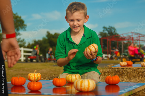 Boy concentrating on finishing pumpkin tic tac toe game outside