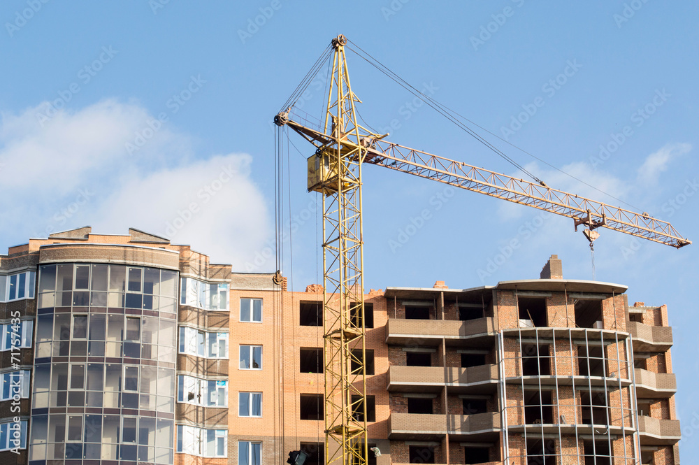 Fototapeta premium Construction of the new brick building by means of the elevating