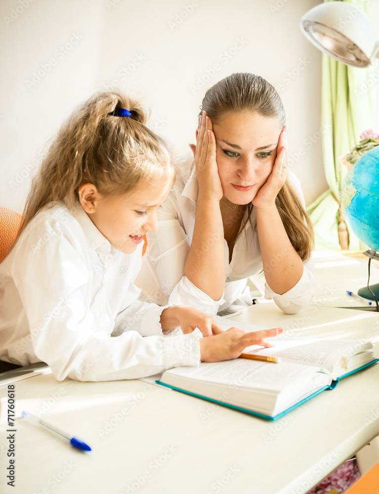 confused mother looking at daughters homework confused mother looking at daughters homework