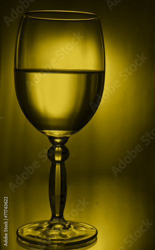 silhouette of a glass with a drink in the yellow light