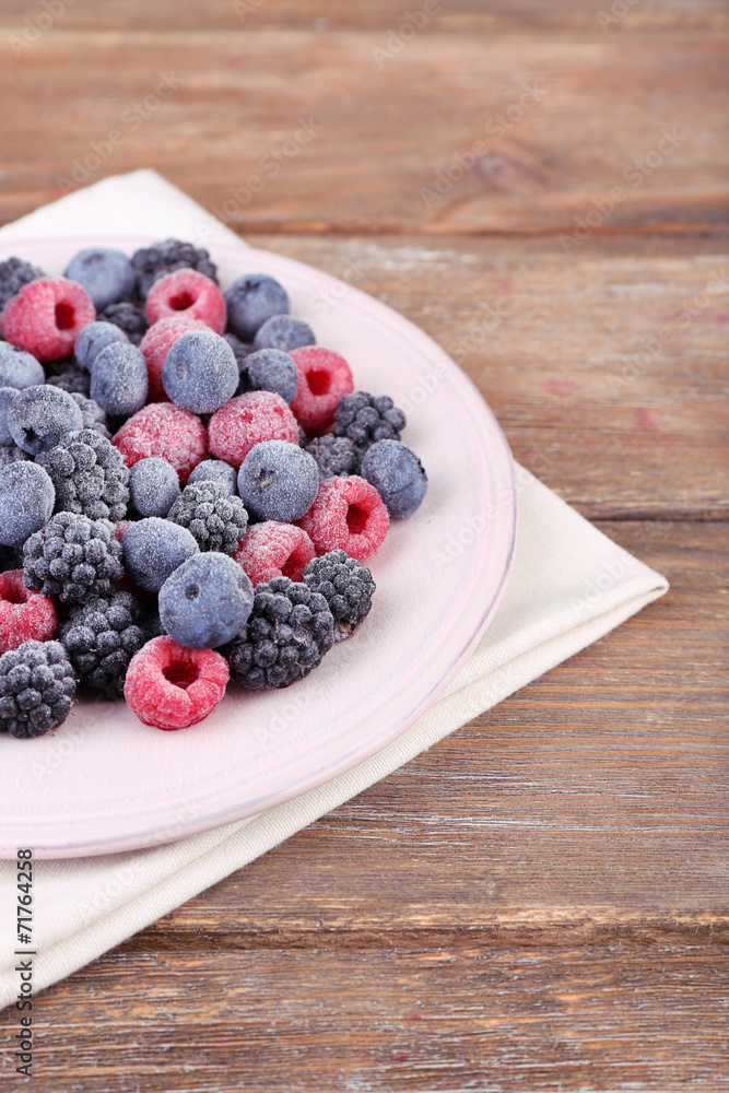 Iced berries on plate, on wooden background Iced berries on plate, on wooden background