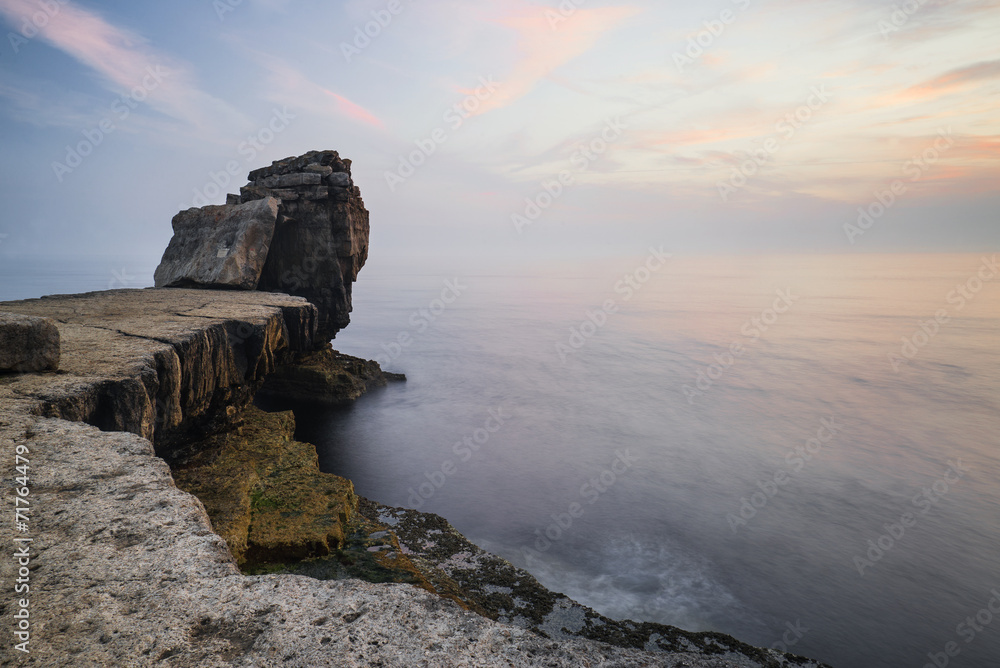 Beautiful rocky cliff landscape with sunset over ocean