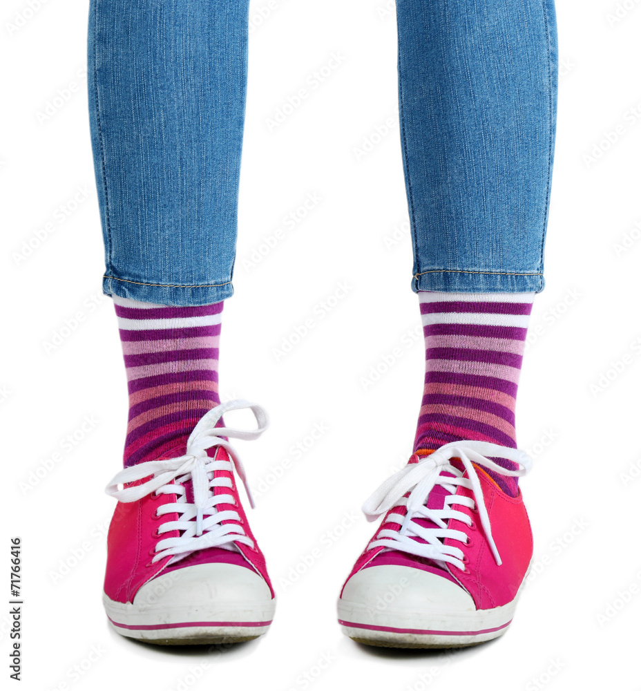 Female legs in colorful socks and sneakers isolated on white Female legs in colorful socks and sneakers isolated on white