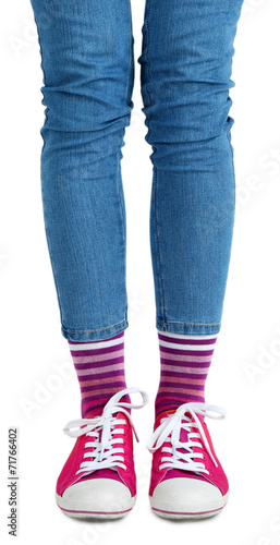 Female legs in colorful socks and sneakers isolated on white