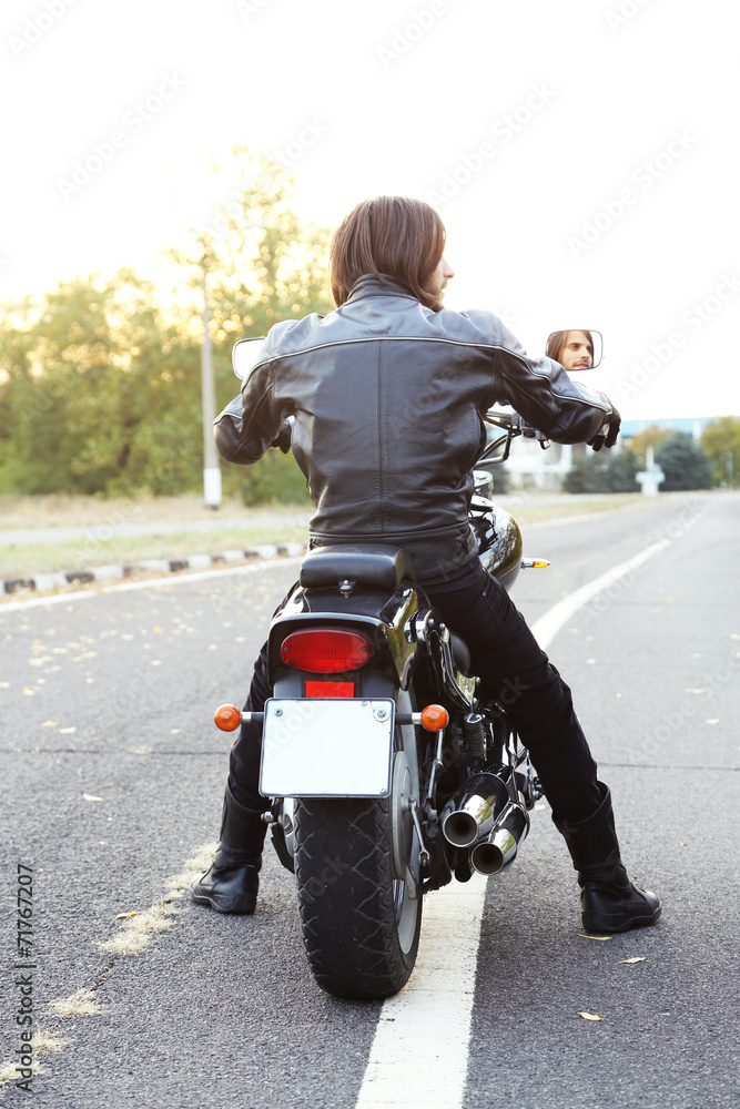 Obraz premium Biker man sits on bike
