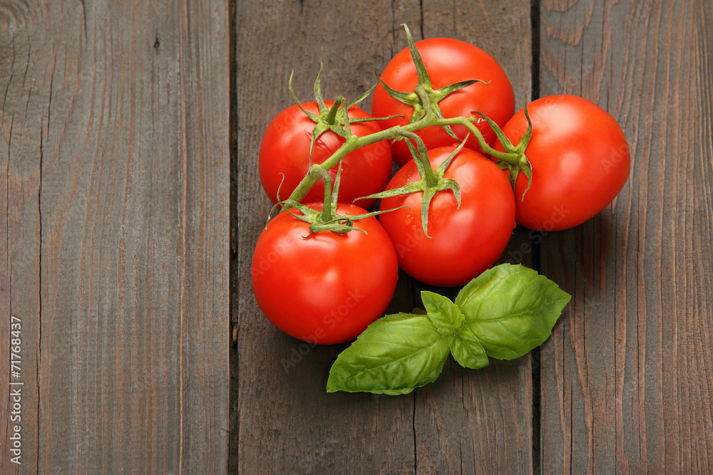 Ripe tomatoes with basil, on wooden background Ripe tomatoes with basil, on wooden background