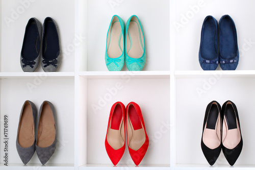 Colorful female shoes on wooden shelves