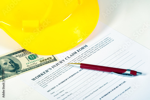 Worker injury claim hard hat with money and pen on white photo