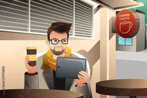 Trendy young man using tablet in a cafe