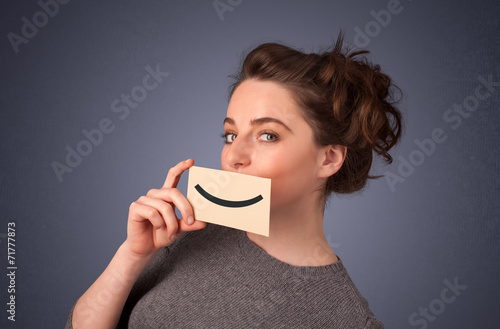 Happy pretty woman holding card with funny smiley