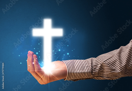 Glowing cross in the hand of a businessman