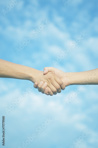 青空と握手する2人の手 © green