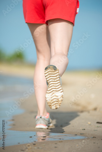 Sport footwear, sand footprints and legs close up. Runner feet d