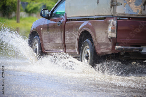 Splash by a car as it goes through flood water © lightmemorystock
