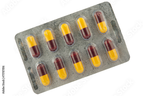 Brown and yellow capsule in blister pack show medicine concept