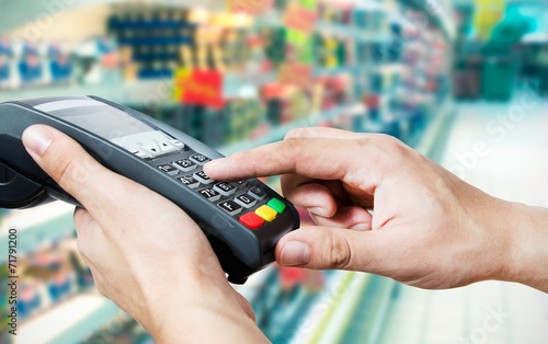 Hand with credit card swipe through terminal for sale in superma