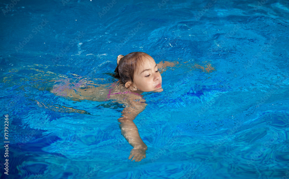 girl trying to hold on water surface at swimming pool