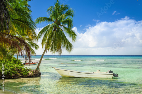 Foto Beautiful beach with palm trees and moored fishing boat