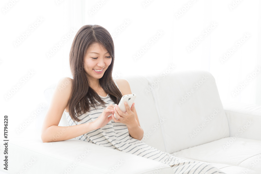 部屋でスマートフォンを見る女性 部屋でスマートフォンを見る女性