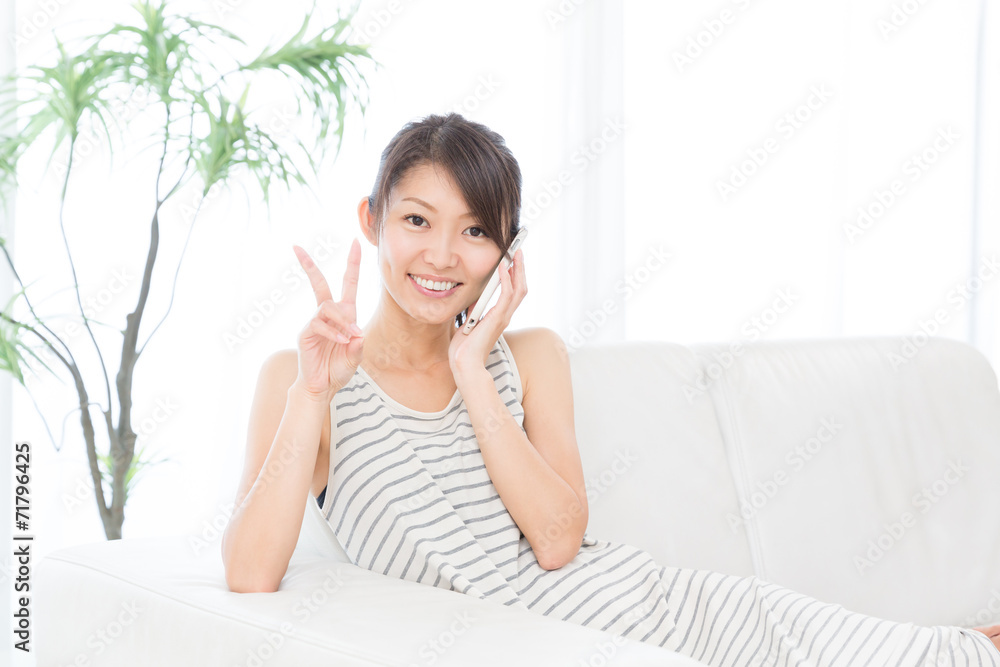 部屋で電話をする女性