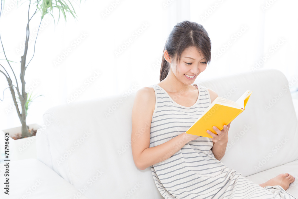 部屋で本を読む女性