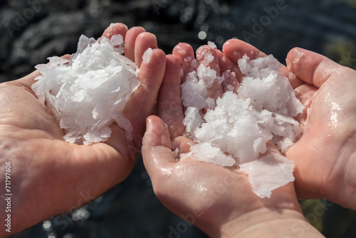 Three hands holding ocean salt
