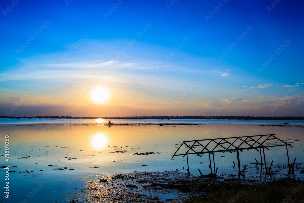 sunset sky over lake or river and home with flood