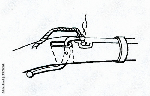 Primitive matchlock (serpentine lock) with burning match photo