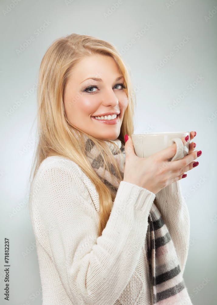Woman having a cup of tea to warm up. Studio shot. Woman having a cup of tea to warm up. Studio shot.