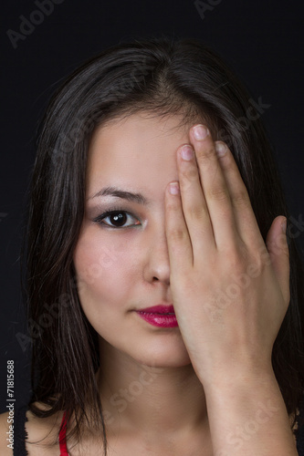 beautiful young asian girl with a hand on her face