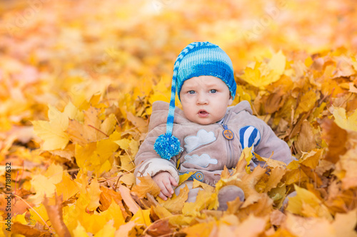 Cute baby in autumn leasves.