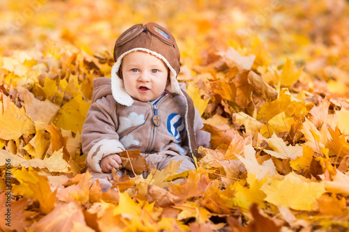 Cute baby in autumn leasves.