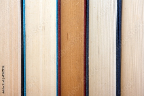 Old hardback books in a row form a background image