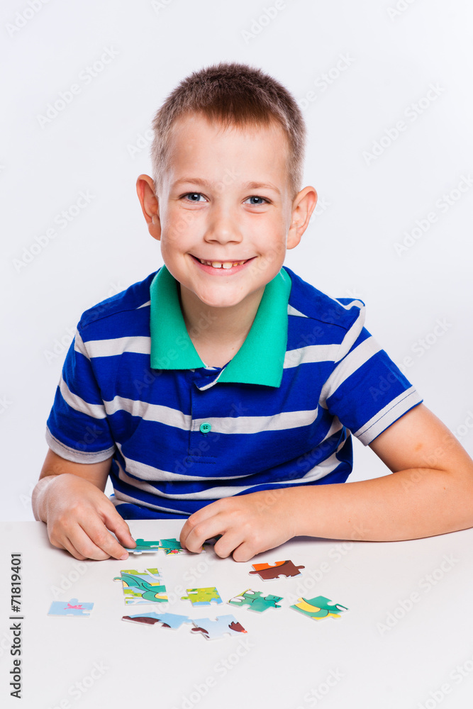 Cute little boy playing puzzles at the table Cute little boy playing puzzles at the table