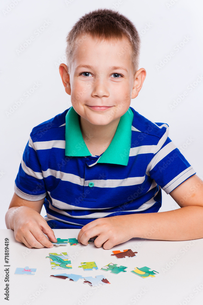 Cute little boy playing puzzles at the table Cute little boy playing puzzles at the table