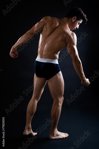 Beautiful and muscular man in dark background.