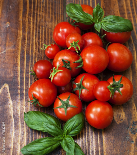 Cherry tomatoes and basil on wooden background © Melinda Nagy