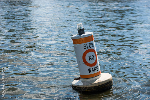 A no wake zone buoy in a river photo