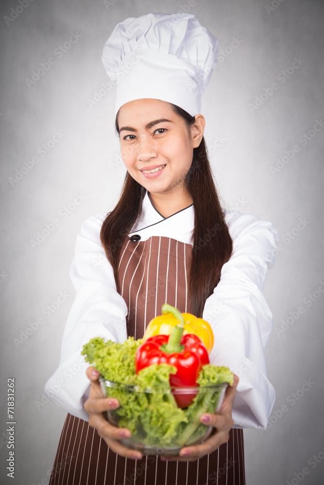 Woman chef holding bowl of fresh vegetables Woman chef holding bowl of fresh vegetables