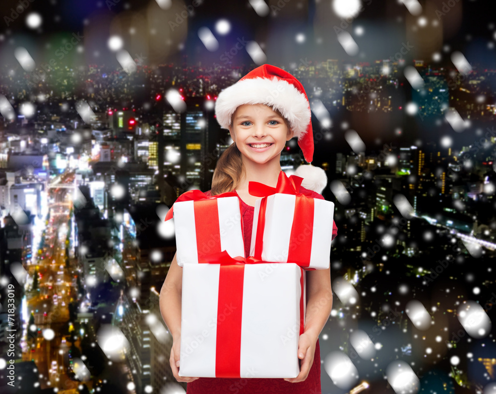 smiling little girl in santa helper hat with gifts smiling little girl in santa helper hat with gifts