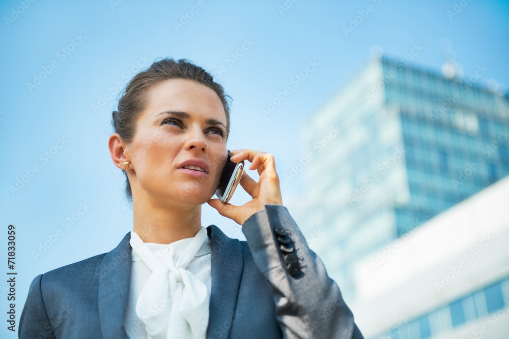 Business woman talking mobile phone in office district Business woman talking mobile phone in office district