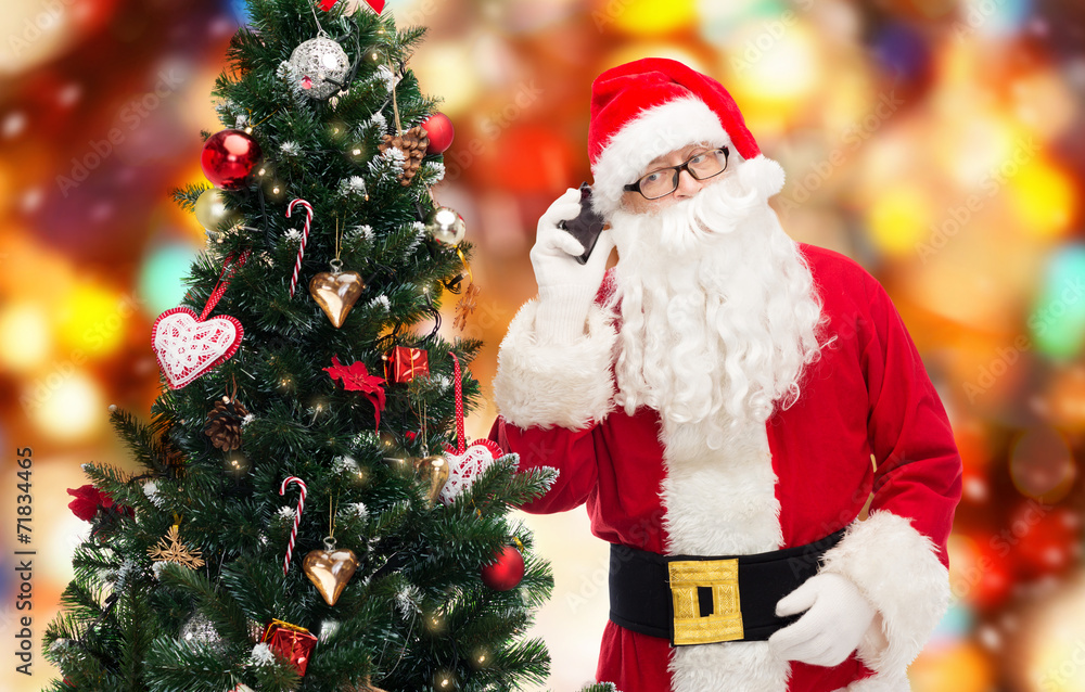 santa claus with smartphone and christmas tree santa claus with smartphone and christmas tree