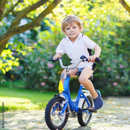 Adorable child having fun with riding his first bicycle © Irina Schmidt