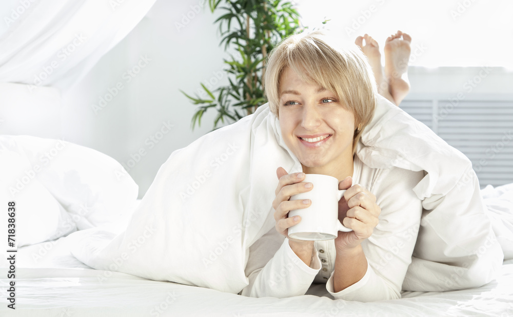 beautiful girl in the morning in bed with cup
