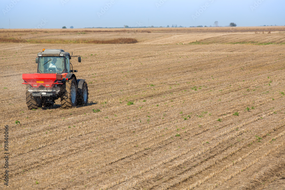 Obraz premium Farmer fertilizing soybean residues field with npk fertilizer