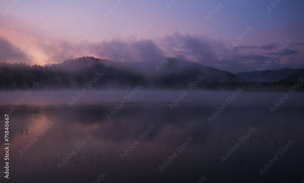 Fog at dawn over the lake in the Bieszczady Mountains